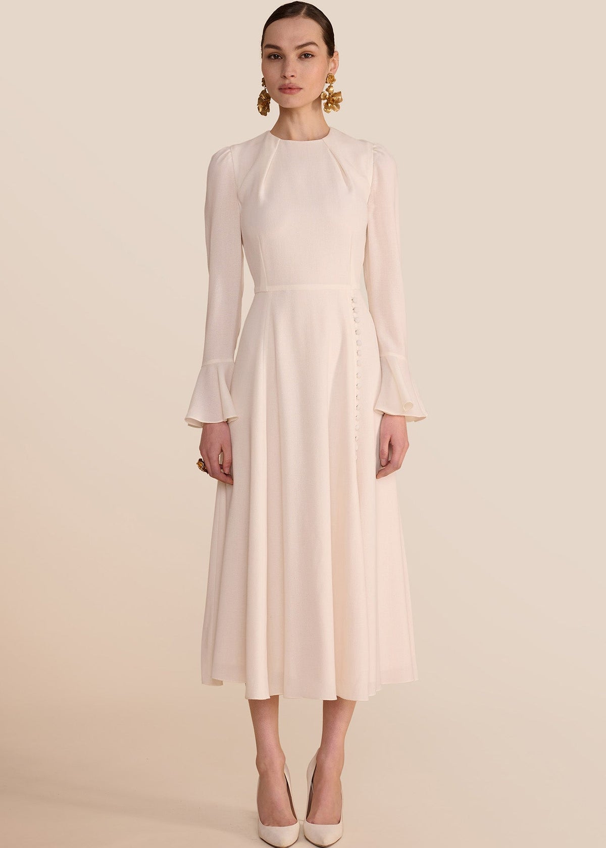 Woman wearing a light pink dress against a beige background